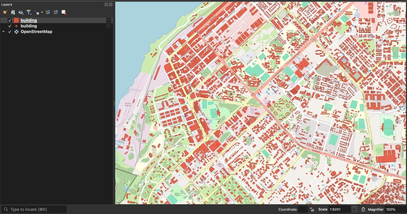 QGIS con 4.560 edifici OpenStreetMap in rosso sopra la basemap OpenStreetMap di Kisumu centrale, e due layer chiamati building nel pannello Layers con l'icona di layer temporaneo.