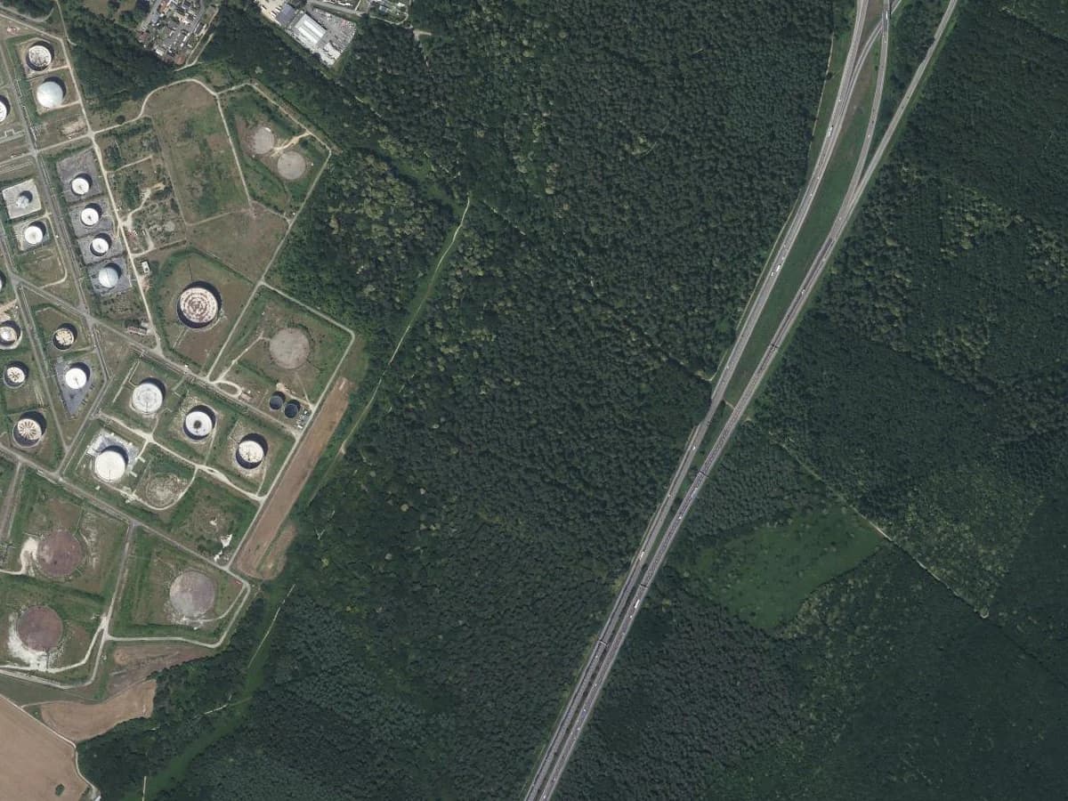 The former Petit-Couronne refinery near Rouen on the IGN orthophoto: storage tanks, bare pads where tanks have gone, internal roads that serve nothing.