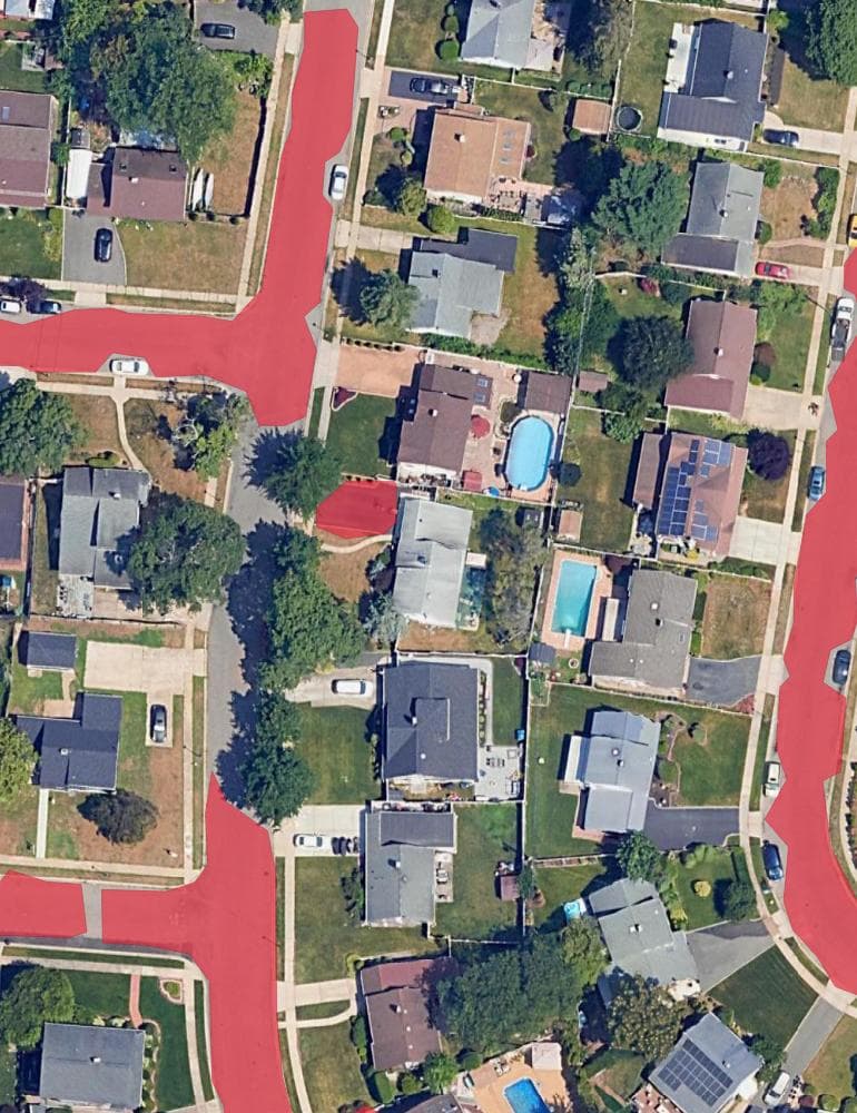 The same road layer over a tree-lined street: the polygon runs solid in the open and stops at each canopy overhang, leaving three gaps along one block.