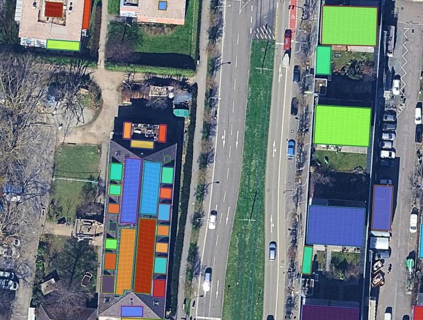 A farm building roof on aerial imagery in QGIS, with five separate solar panel groups each outlined as its own coloured polygon and the bare roof between them untouched.