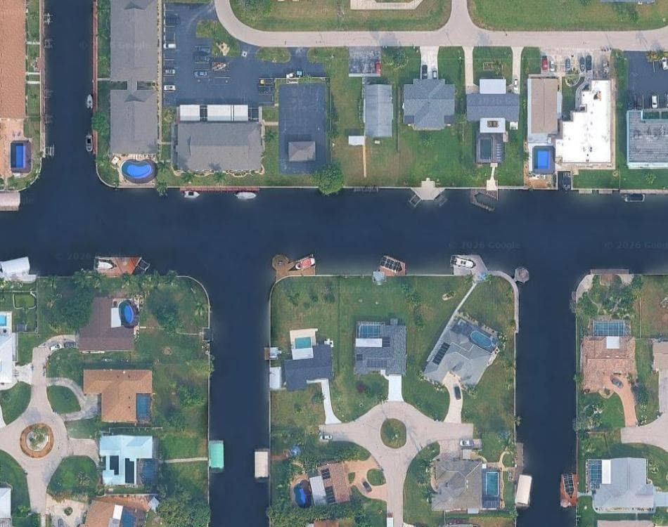 A suburban block on satellite imagery with OSM swimming pool polygons in blue over three pools, and seven other visible pools with no polygon at all.