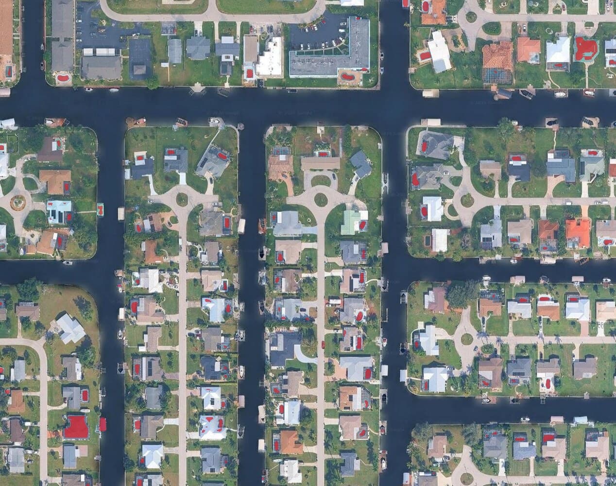 A suburban orthophoto with a red mask from the raster calculator covering every swimming pool, a blue metal roof, and a blue tarpaulin over a woodpile.