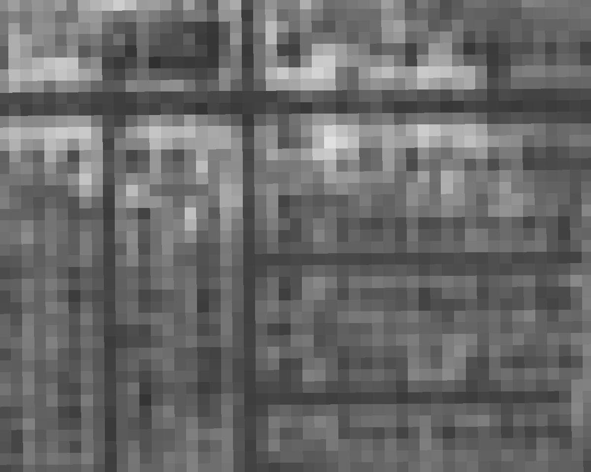 An NDVI raster over a French village in QGIS, vegetation bright and roofs dark, with the layer histogram beside it showing two peaks.