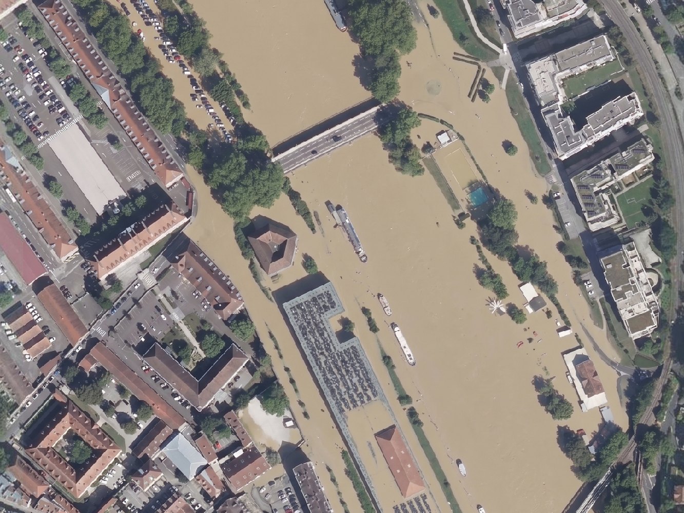 A flood covering the whole frame, then the same flood confined to the river corridor with the town on its terrace left dry (after)
