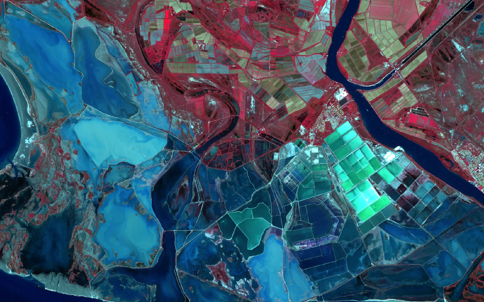 Hetzelfde deel van de Rhônedelta in ware kleuren en in valse kleuren. In valse kleuren is de rivier donkerblauw, zijn de ondiepe lagunes lichtblauw, de zoutpannen turquoise en de vegetatie langs de rivier rood. (after)